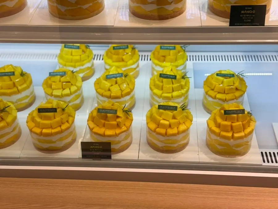 Mango cake topped with whole mangoes in the showcase