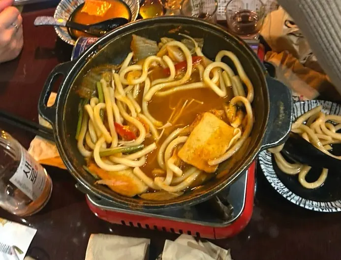 Fried tofu kimchi udon broth starting to boil
