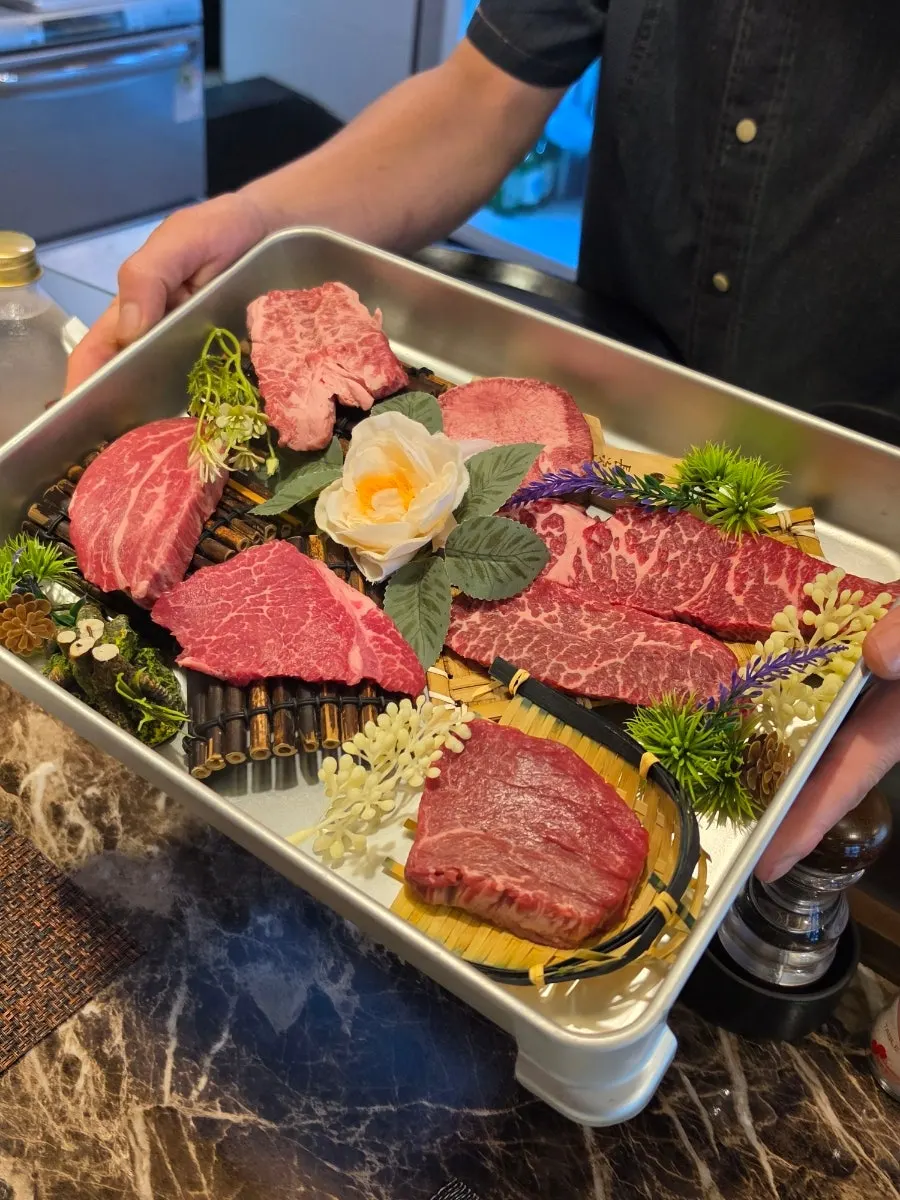 Raw beef cuts presented on a plate with flower decoration