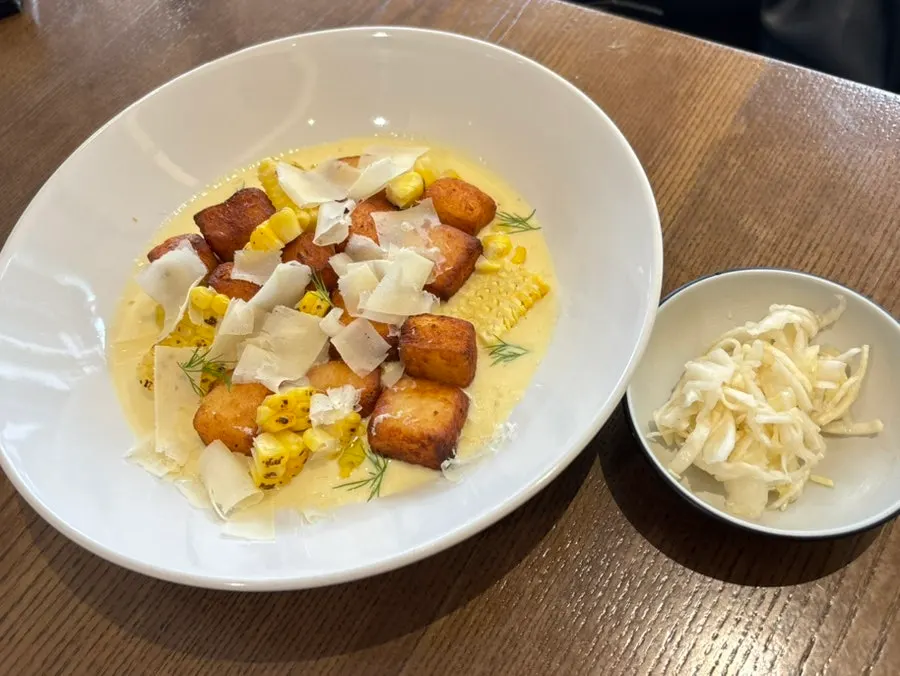Fried potato gnocchi over sweet corn cream sauce