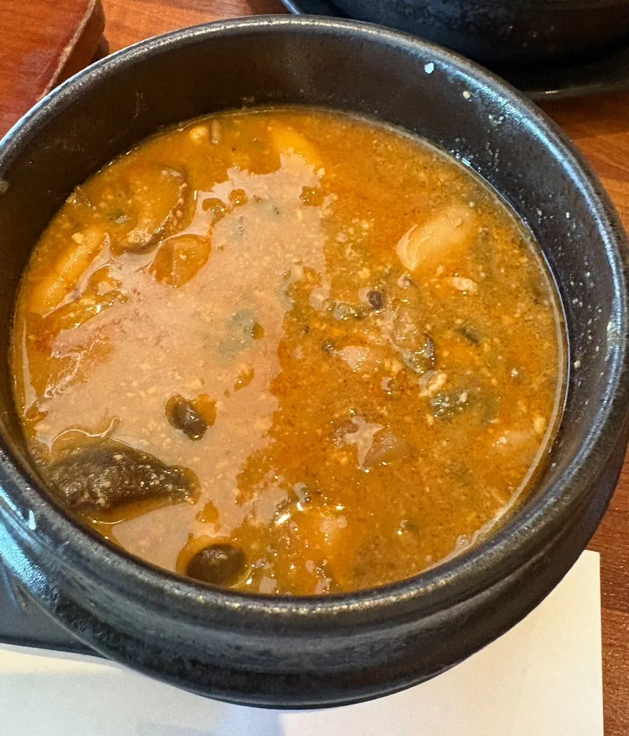 Doenjang jjigae with tofu and vegetables, plus namul side dishes