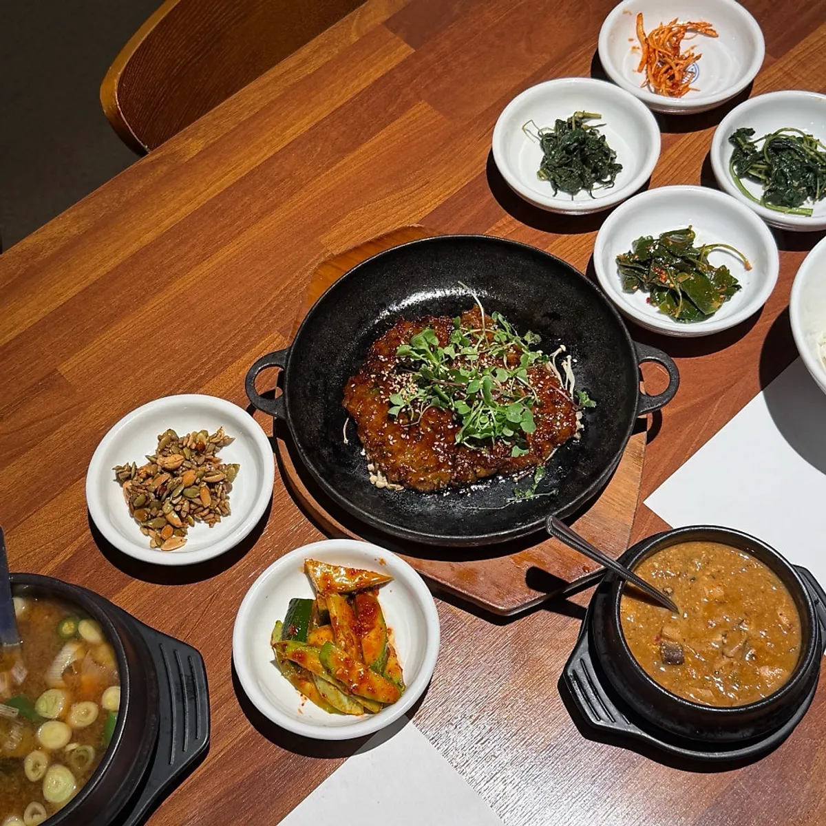 Stone-plate tteokgalbi with the full meal spread at Bapkkot Hansang