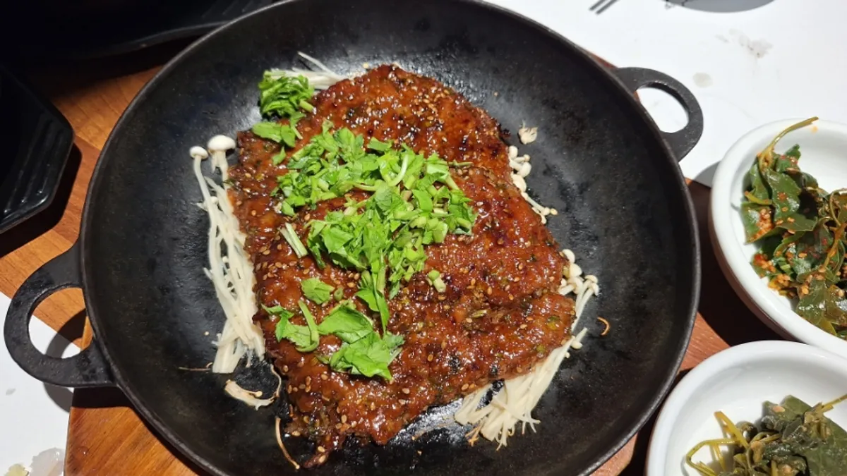 철판 위 팽이버섯과 미나리를 올린 떡갈비