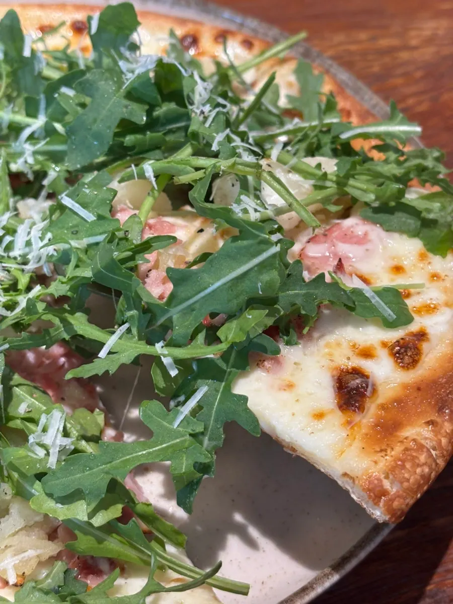 Pizza topped with arugula and potato