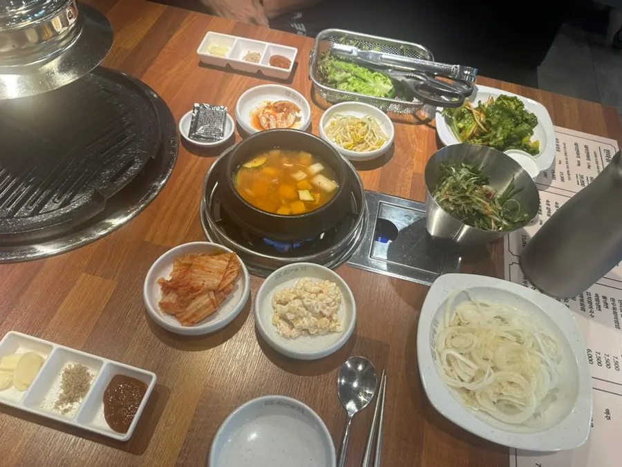 Table setting with basic side dishes, wraps, and doenjang jjigae