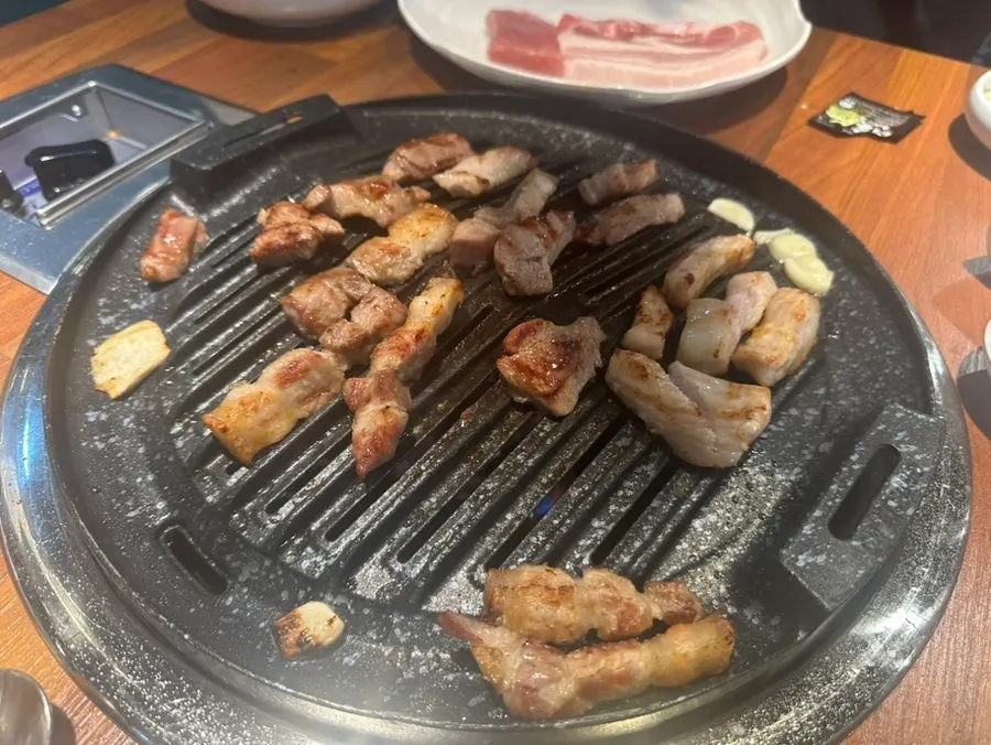 Garlic and meat grilled at the edge of the pan
