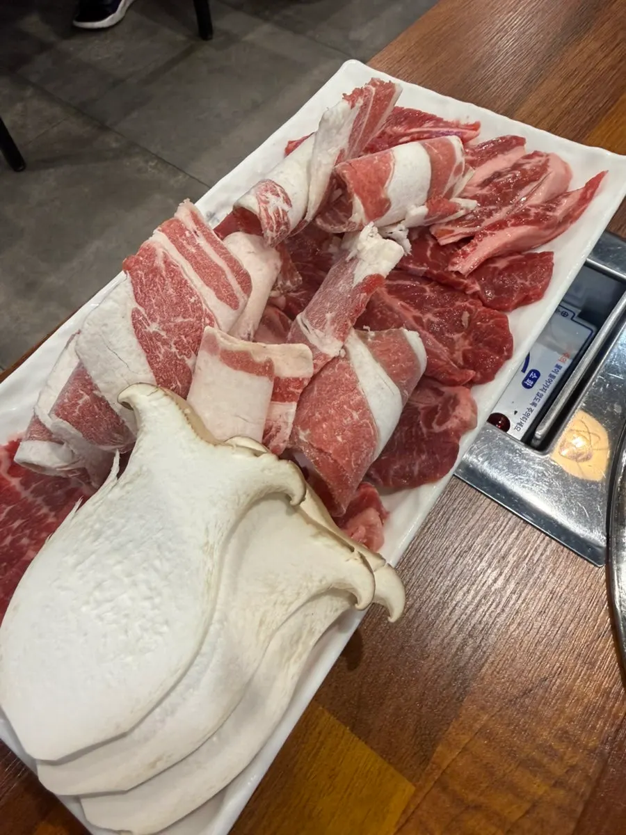 Mushrooms grilling alongside beef
