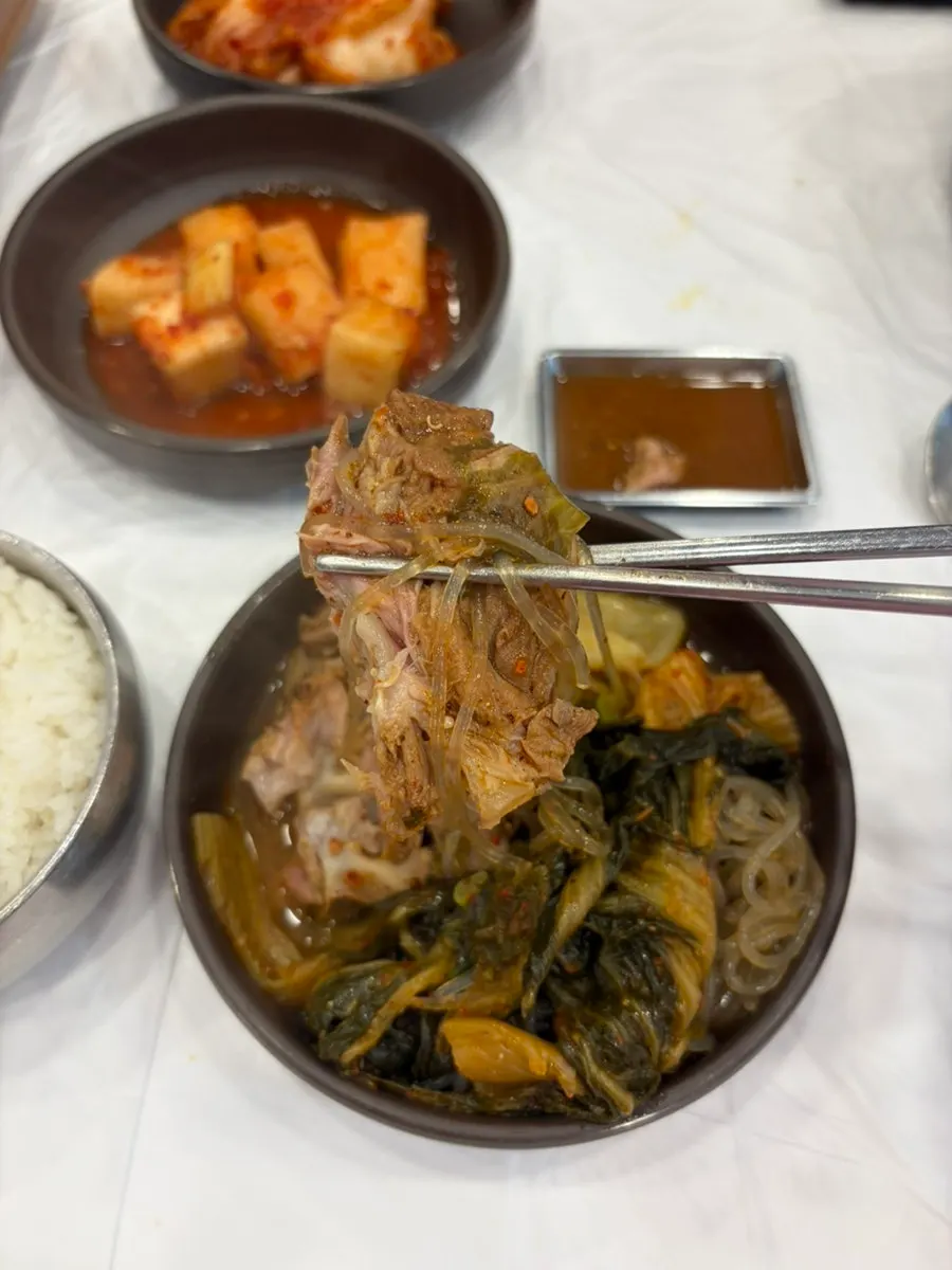 Pot of gamjatang generously filled with perilla leaves and pork bones