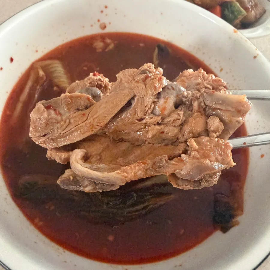 A bowl of clear pork bone soup broth scooped out