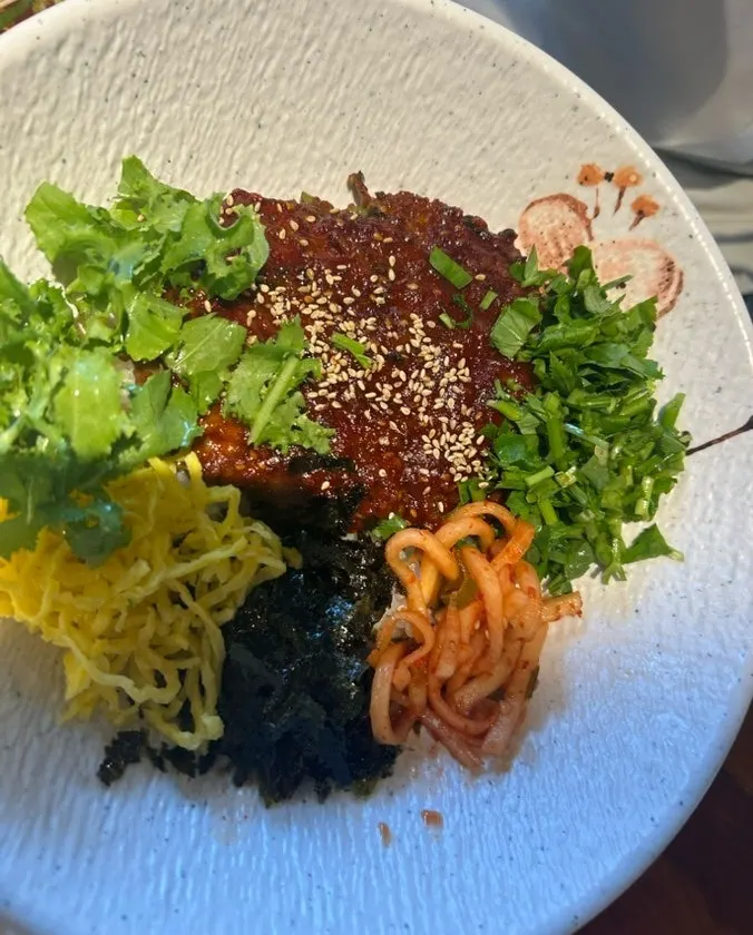 A bowl of gochujang-flavor minari tteokgalbi rice bowl