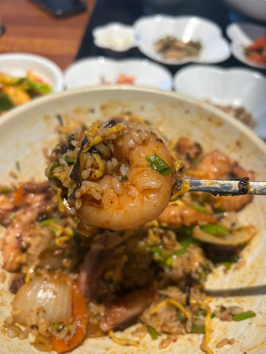 A spoonful of large shrimp and octopus