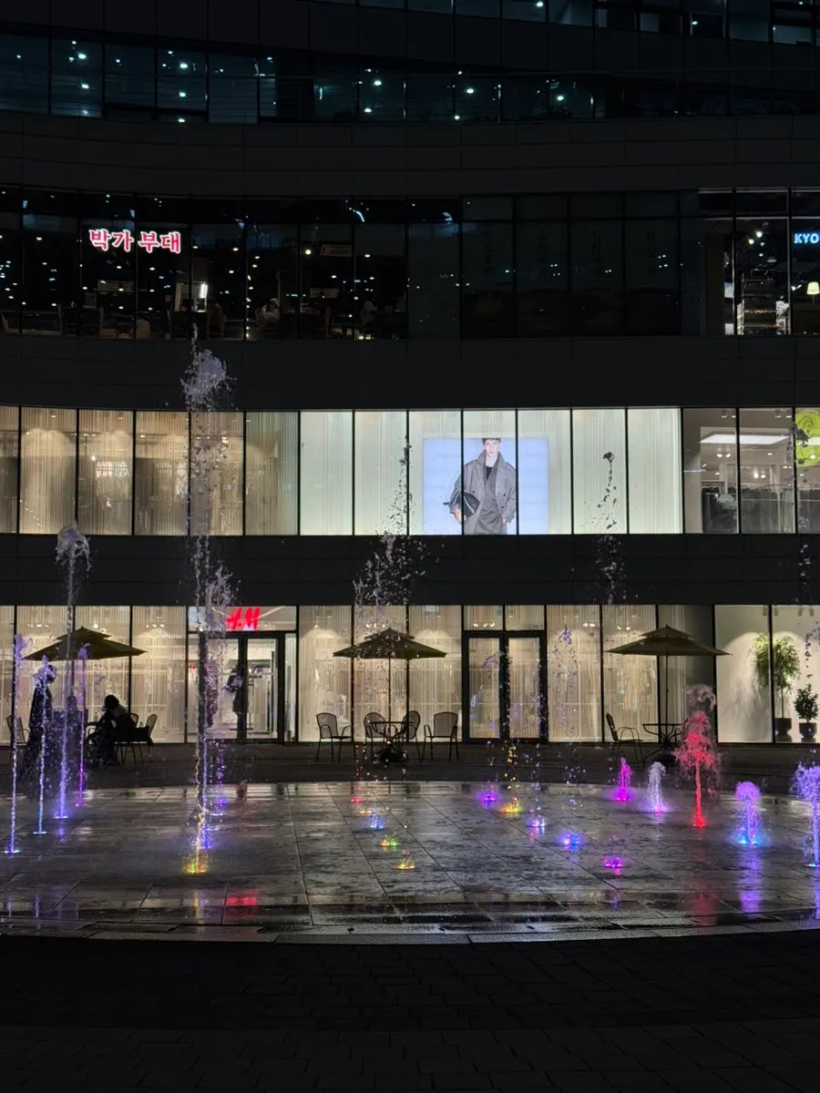 The fountain and evening lighting spread out in front of Le Garden Bleu