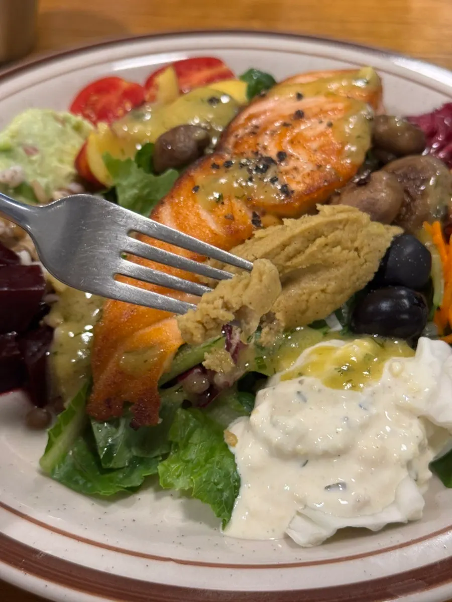 The garden salad layered beneath the salmon