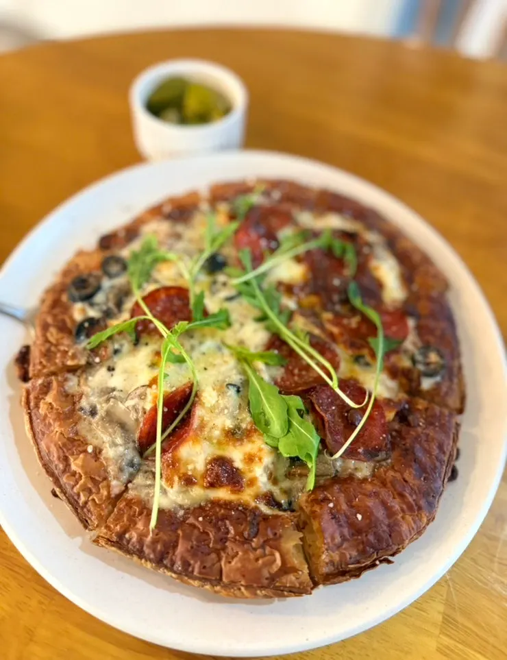 A slice lifted from the pepperoni mushroom pizza