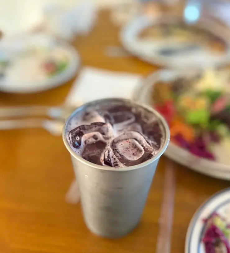 A vividly colored glass of blueberry ade