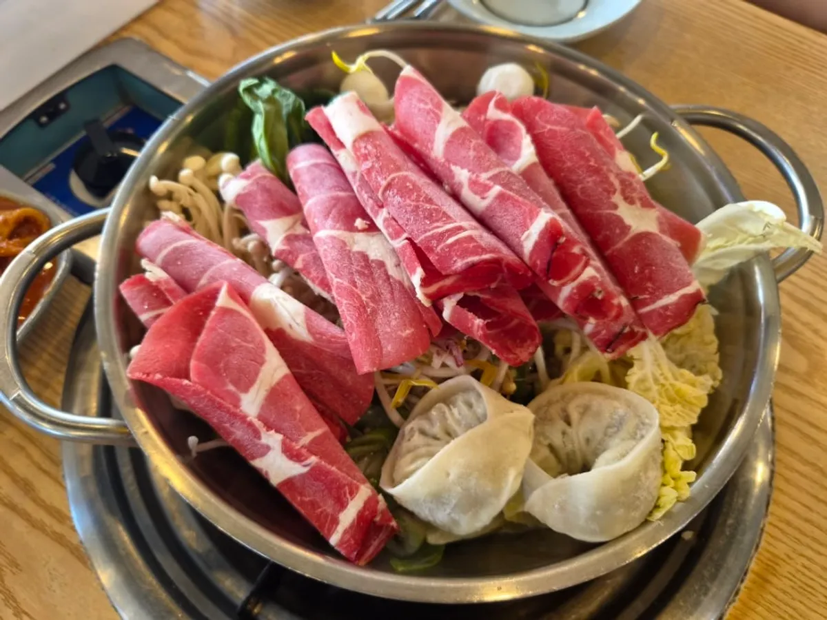 Pot of shabu kalguksu piled high with vegetables and beef