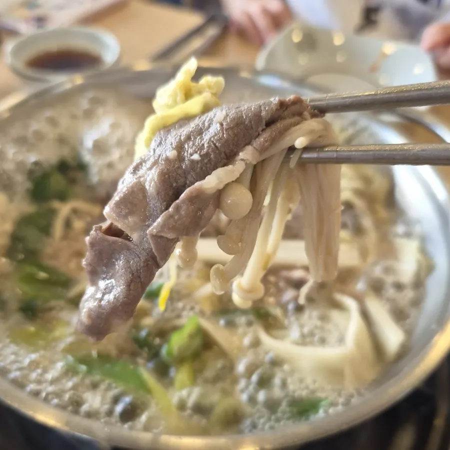 A spoonful of broth scooped from the shabu kalguksu