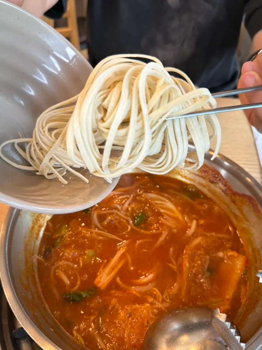 육수에 칼국수 면을 넣는 모습