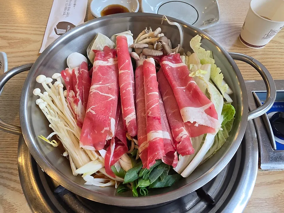 Shabu kalguksu con caldo picante entre los ingredientes