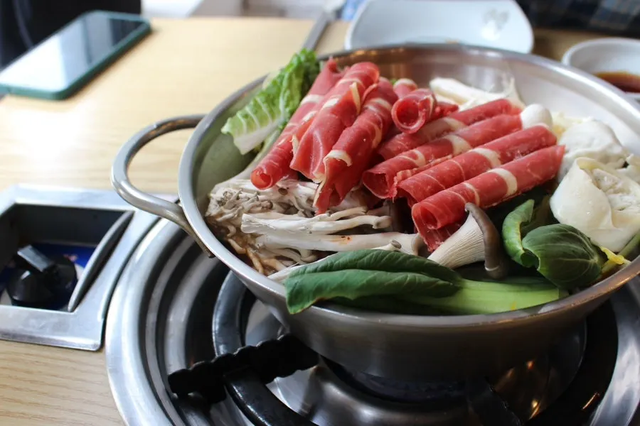 Shabu kalguksu cooking in spicy broth