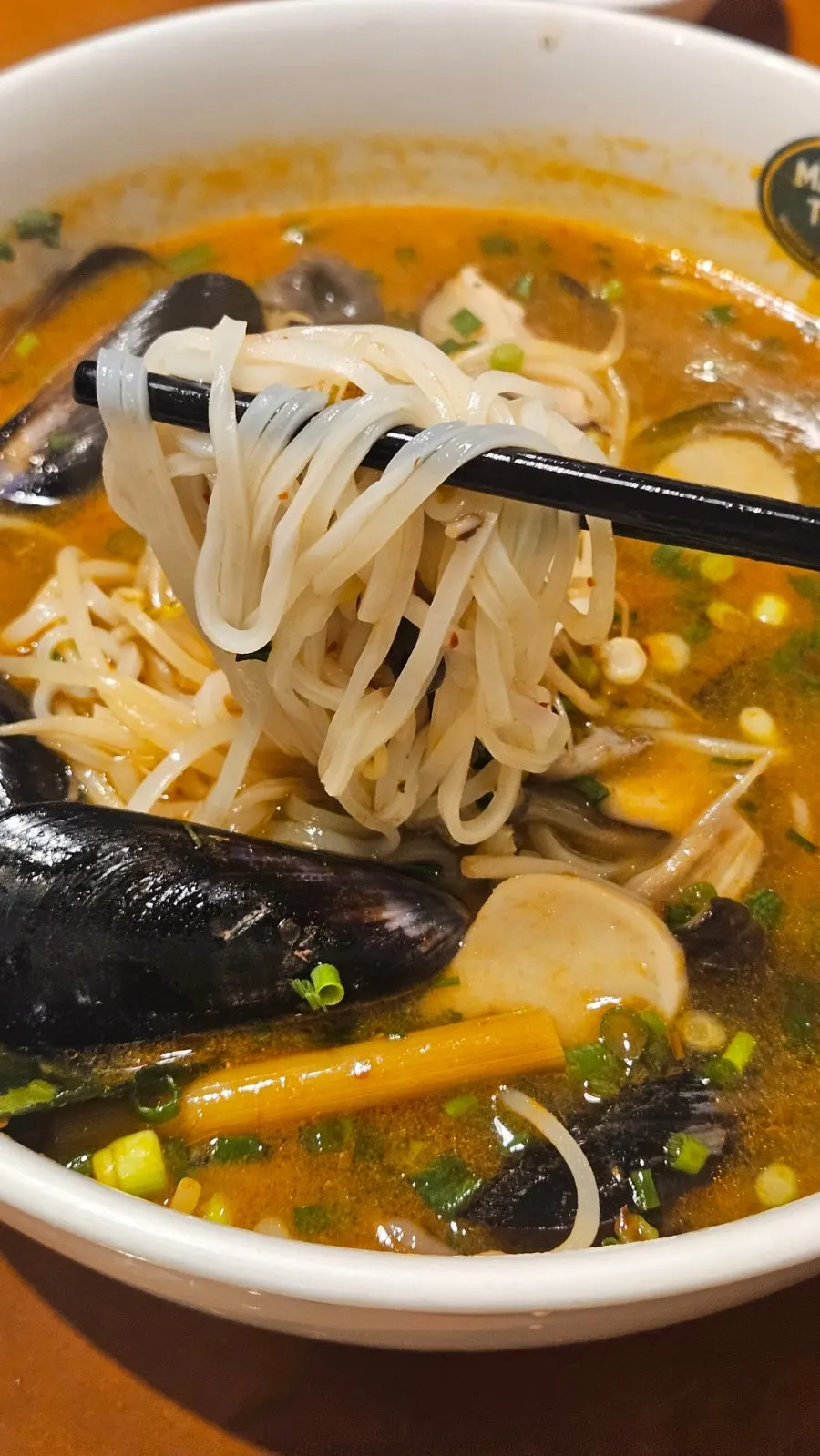 Primer plano del caldo y los ingredientes del tom yum noodle soup