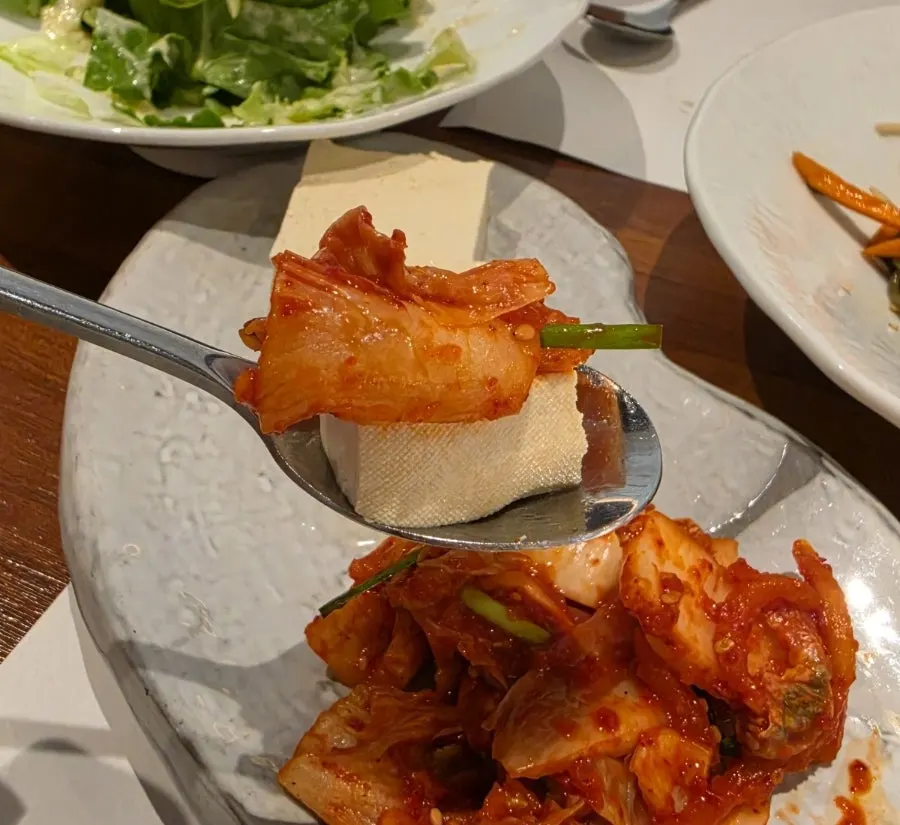 A bite of boiled pork with dressed lettuce