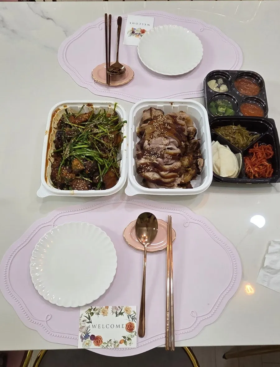 A wrap of jokbal with lettuce and side dishes