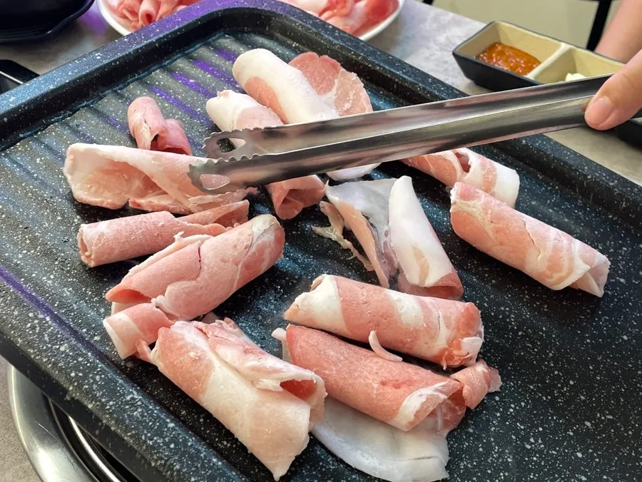 Grilling daepae samgyeopsal on the grill pan