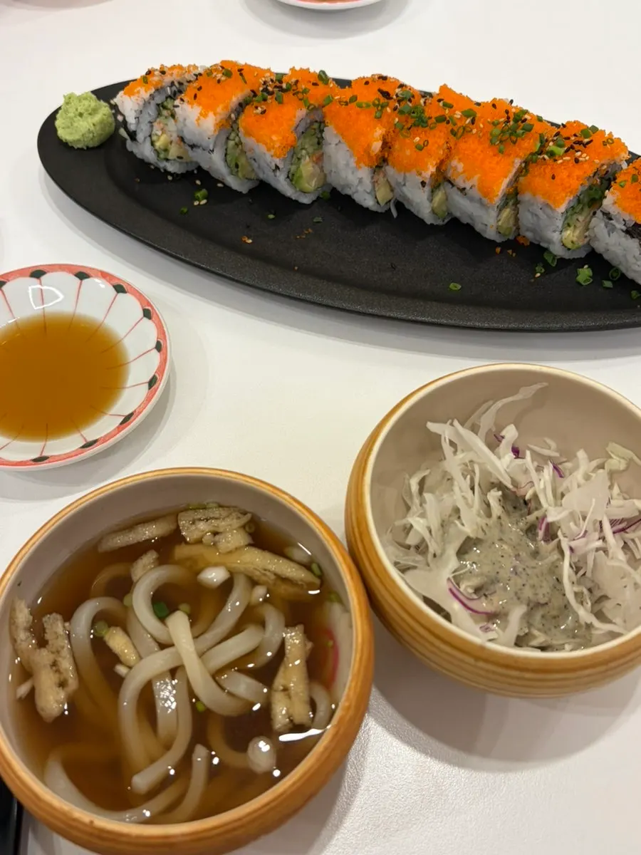 A piece of California roll topped with wasabi