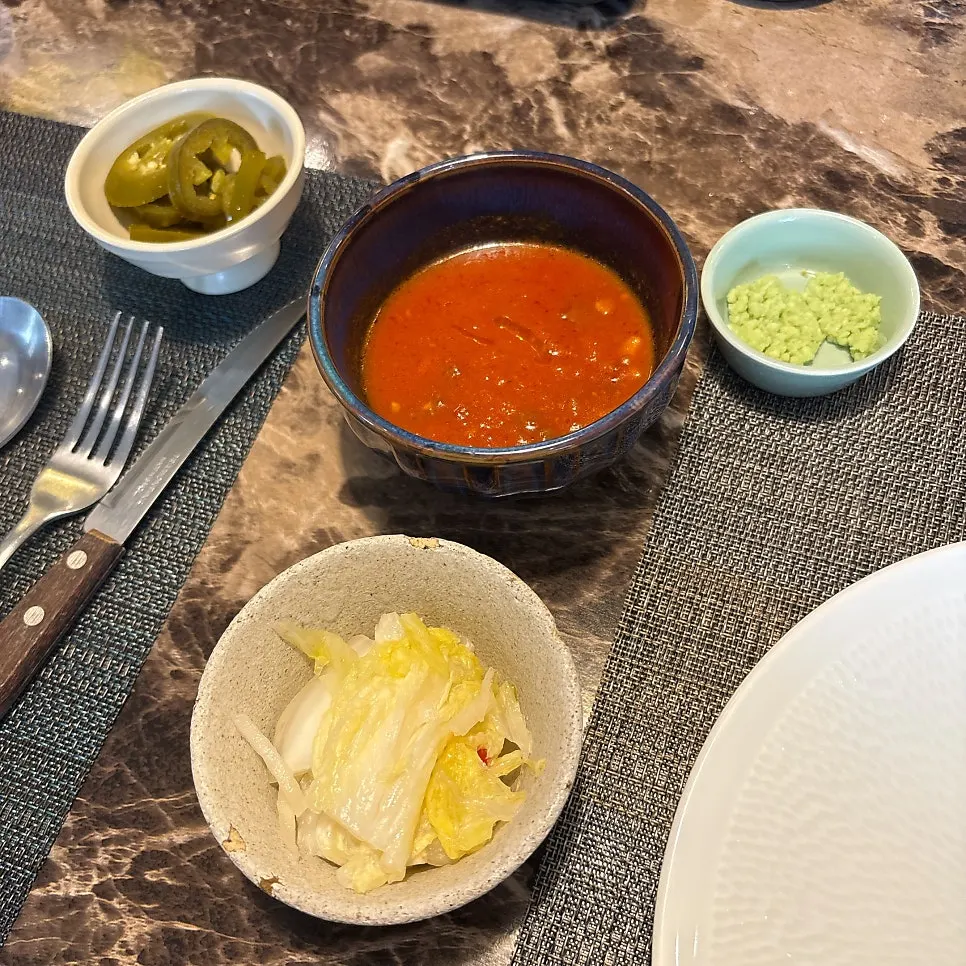 Steak side dishes including white kimchi, jalapeños, and wasabi