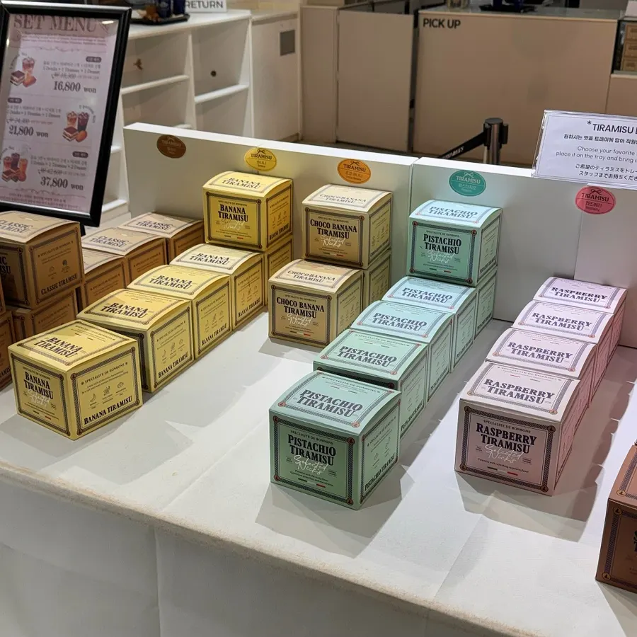 Various tiramisu flavors on display with gift boxes
