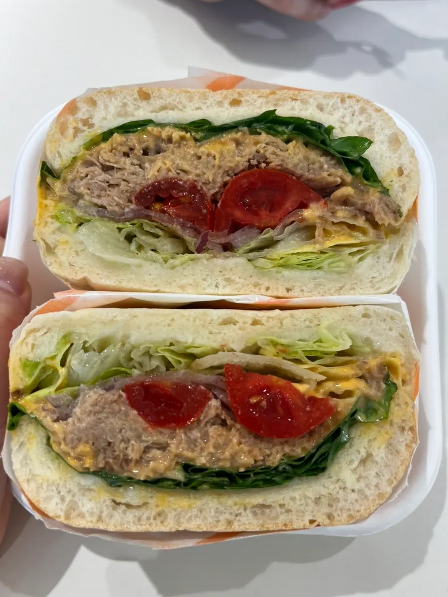 Cross-section of the sandwich showing pulled pork and spicy sauce