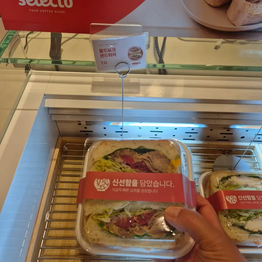 Bên trong Selecto Coffee Sinnonhyeon với bánh và sandwich được bày sẵn
