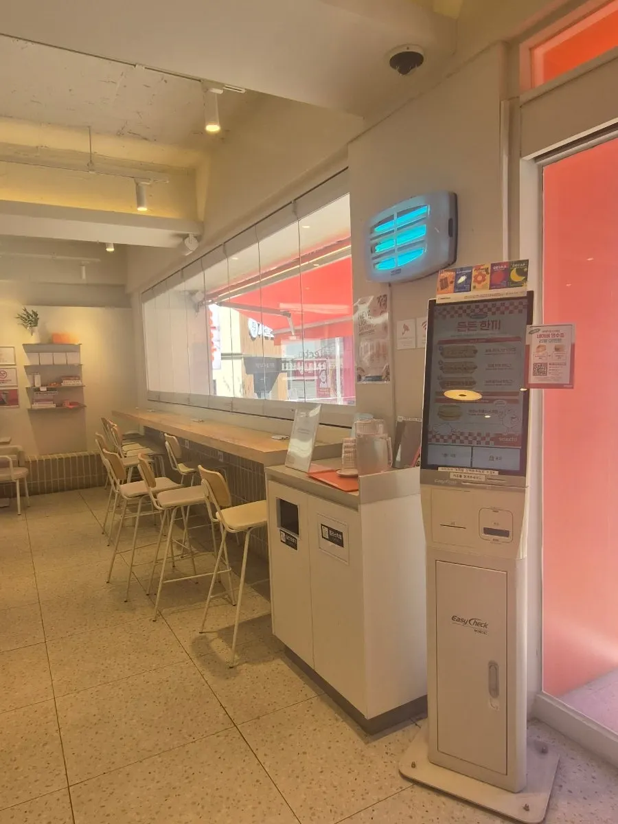 Bahagian dalam Selecto Coffee Sinnonhyeon Branch bertona putih dan kayu