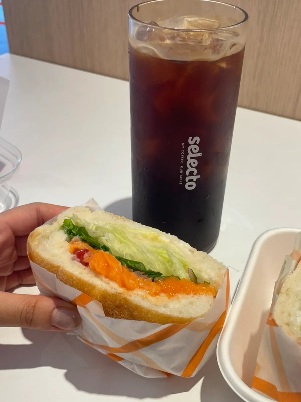 Sandwich and americano together on the table