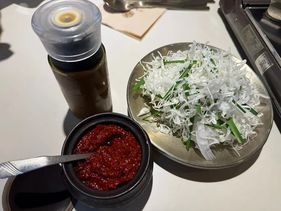 Chive and cabbage salad with house sauce and chili paste