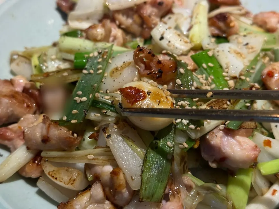 Close-up of grilled chicken cartilage topped with whole garlic