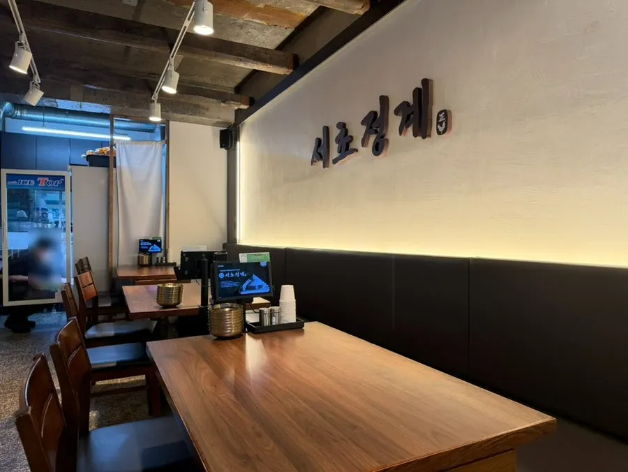 Seating area at Seocho Jeonggye decorated with dark wood tones