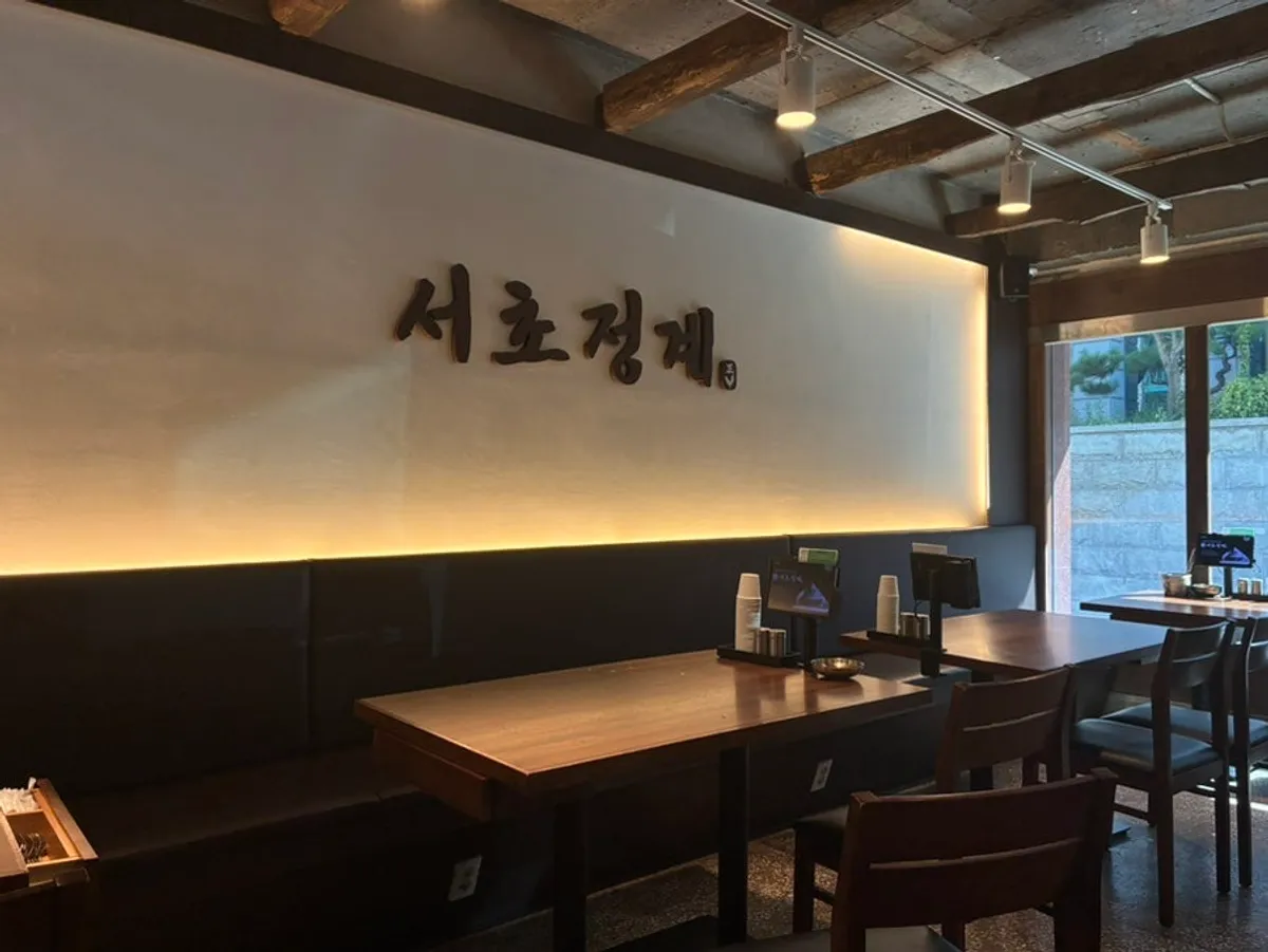 Interior of Seocho Jeonggye with the restaurant's name in large letters on the wall