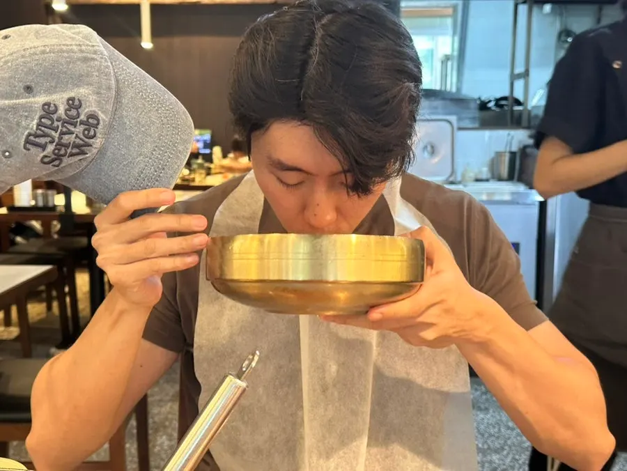 Lifting a chopstick-full of chogyeguksu noodles