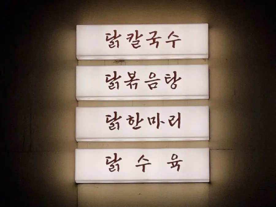 Wood-toned sign and entrance of Seocho Jeonggye
