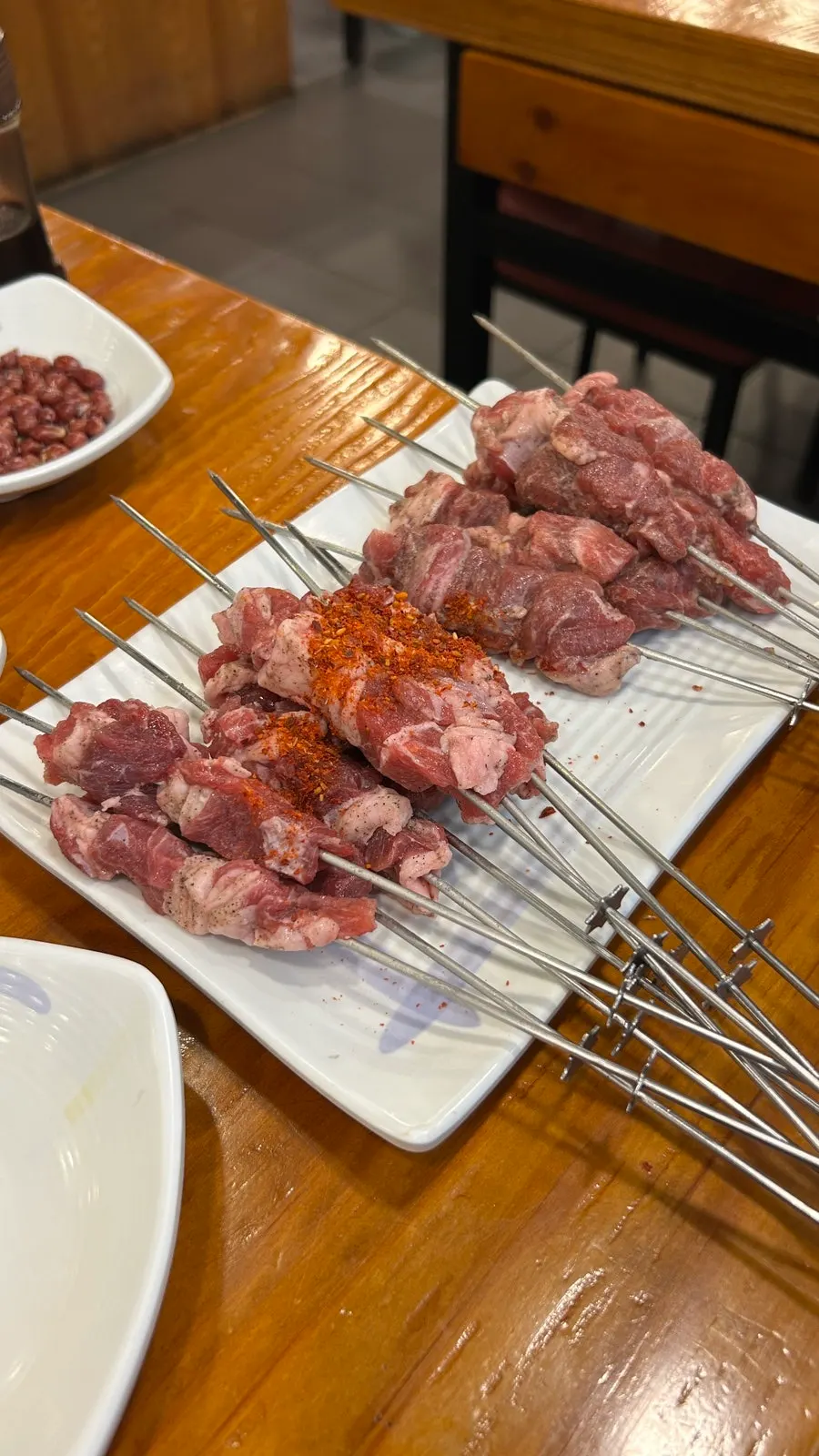 Raw lamb skewers and tenderloin skewers served on a plate