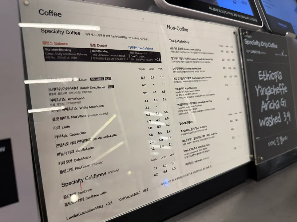 Drink menu board listing coffee, cold brew, teas, and ades