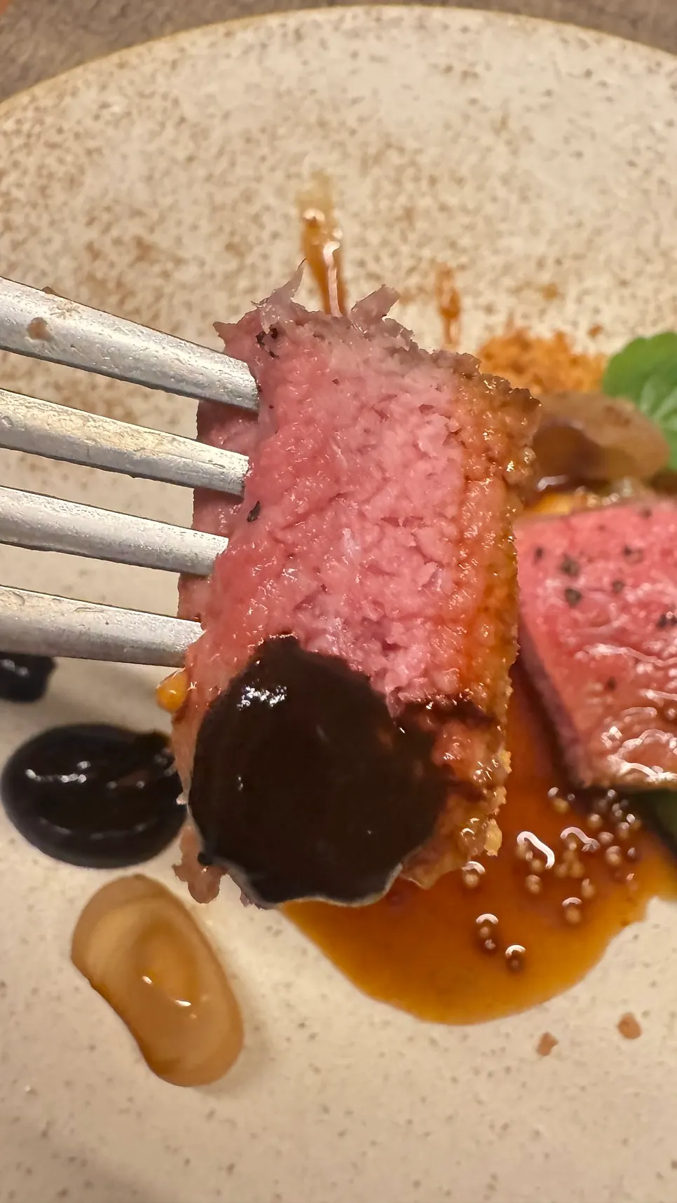 Steak served with black garlic purée and potato crumble