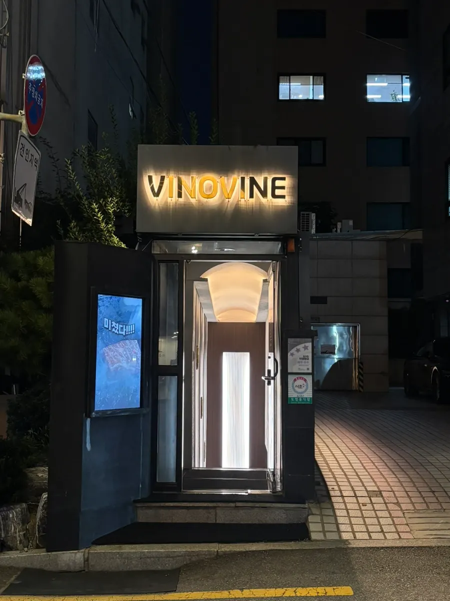Vinovine's VINOVINE sign and exterior lit up at night