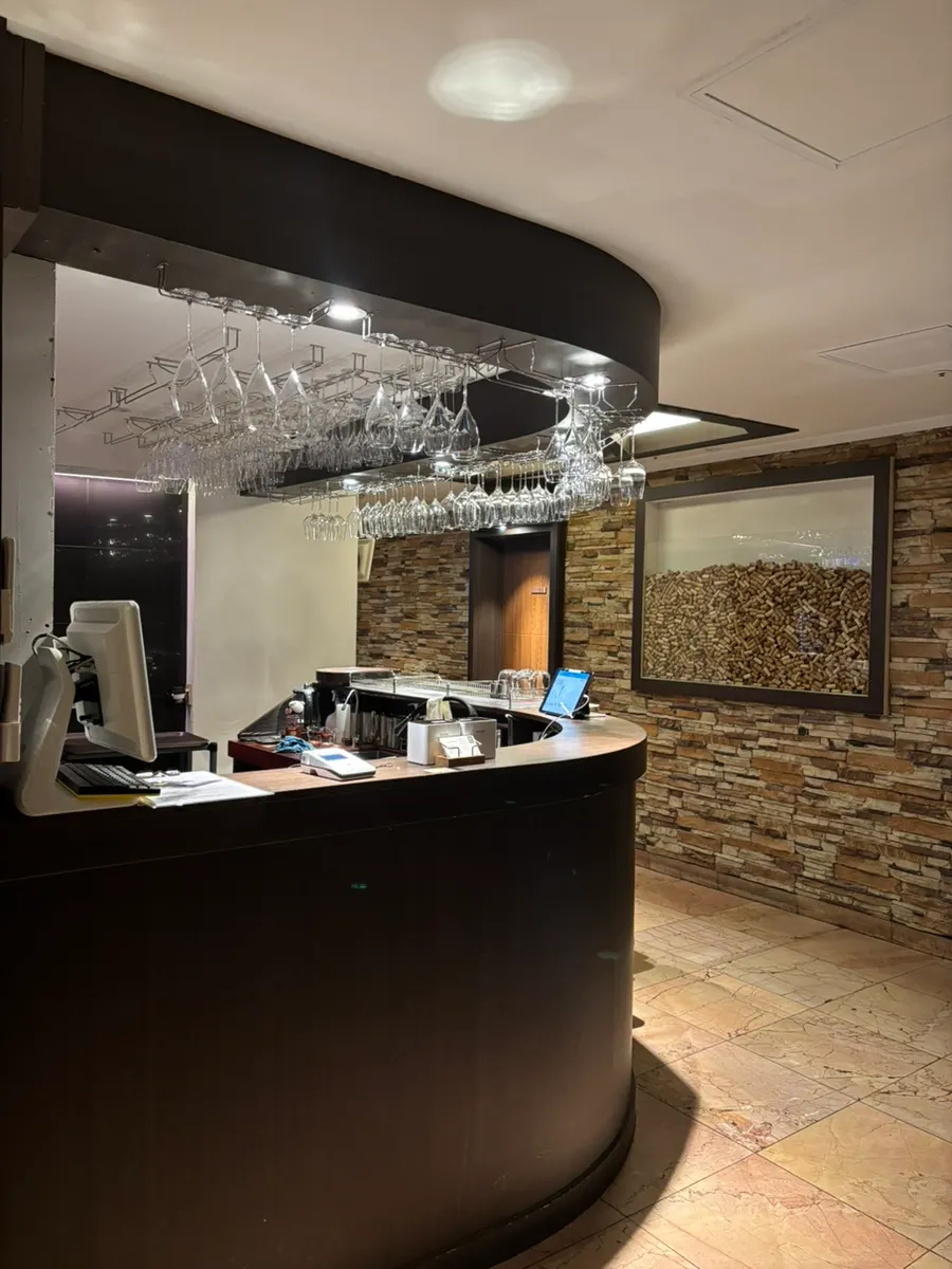 Vinovine's entrance with a wood counter and wine glasses hanging above it