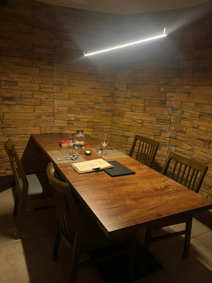 A dining room at Vinovine with wood-toned walls and yellow lighting