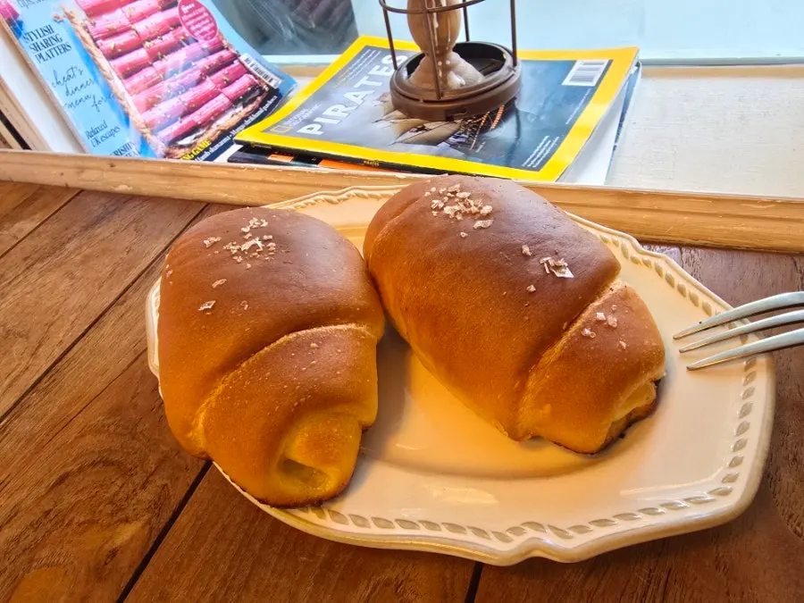 창가 테이블 위 빵과 음료 세팅