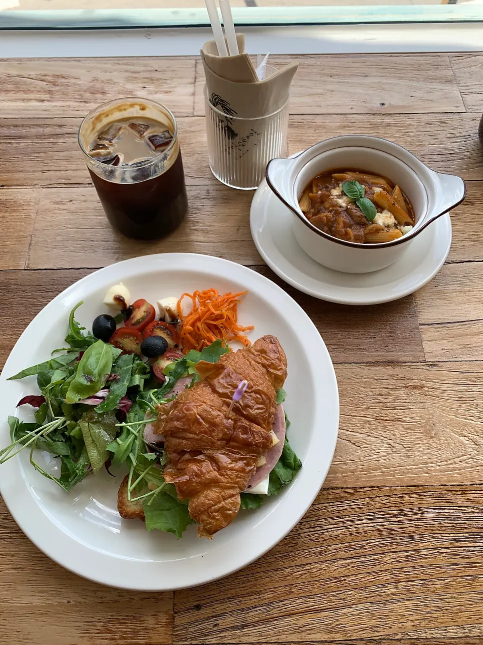 Table setting of Lunch Club Course A croissant sandwich and pasta