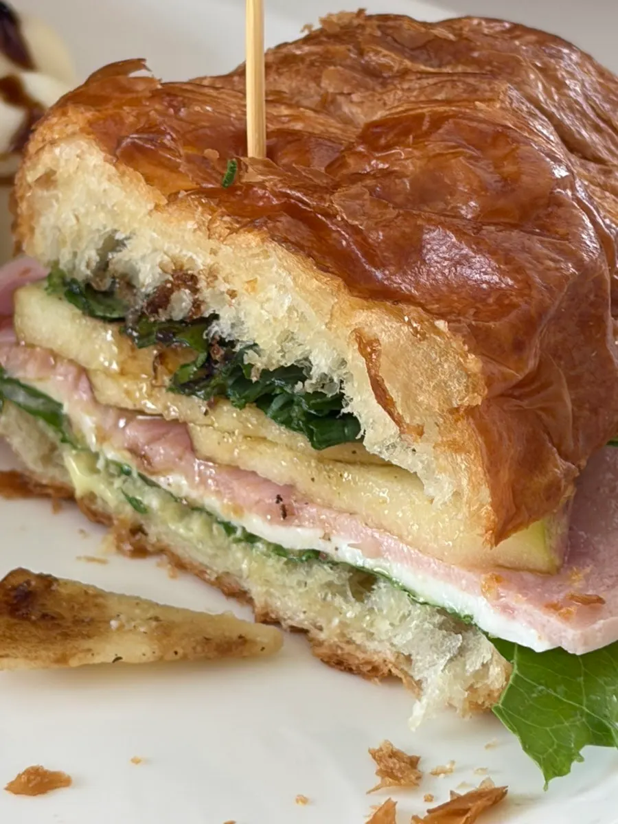 Croissant sandwich with ham, cheese, and apple